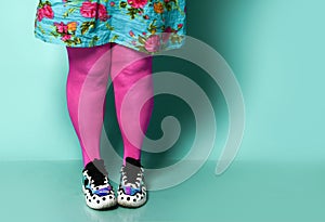 Overweight fat woman legs in modern pink leggings and sneakers close up