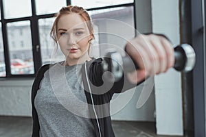 Overweight girl lifting dumbbell