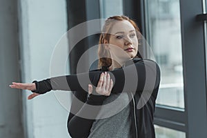 Overweight girl stretching arms