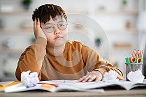Overweight japanese boy doing school project, got tired