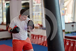 Overweight kickboxer working the heavy bag