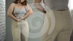 Overweight lady having difficulties with getting into her pants, obesity issue