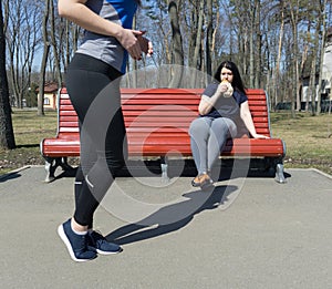 Overweight lazy woman eating junk food instead of training. Outd