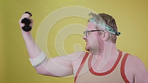 Overweight man doing biceps with one hand, eating a cookie with the other. fat funny man