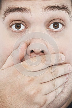 Overweight Man With Hand On Mouth And Raised Eyebrows