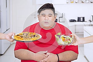 Overweight man looks confused to choose foods