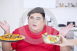 Overweight man looks confused to choose foods