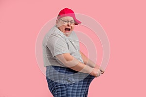 Overweight man pulling ahead his pants, screaming, an not lose weight