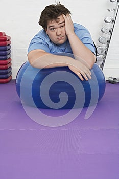 Overweight Man Resting on Exercise Ball