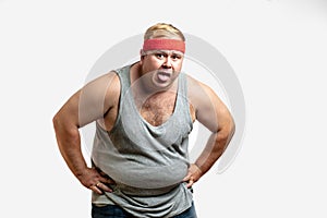Overweight man resting, tired after training, with hand on forehead against white