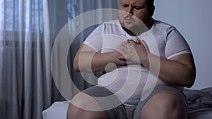 Overweight man suffering from chest pain, high blood pressure, cholesterol level