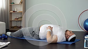 Overweight man trying to do sports exercise, strength and endurance development