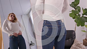 Overweight mature woman struggling to fit into tight jeans after gaining weight