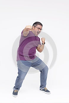 A overweight middle aged guy makes a funny looking punch. Overwhelmed with joy. Full body photo, isolated on a white background
