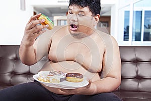 Overweight person eating donuts
