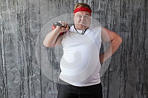 Overweight sportive man shows his strength and competence
