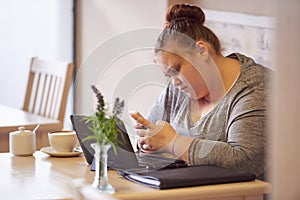 Overweight teenager sitting in a cafe texting with her phone
