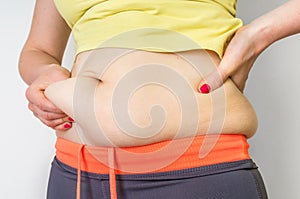 Overweight woman body with fat on belly - obesity concept