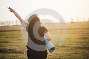 Overweight woman celebrating rising hands to sky