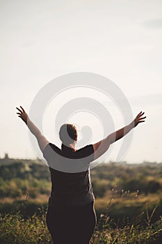 Overweight woman celebrating rising hands to sky
