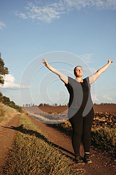 Overweight woman celebrating rising hands to sky