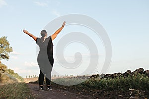 Overweight woman celebrating rising hands to sky