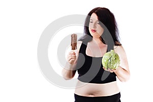 Overweight woman choosing between sweets and healthy food