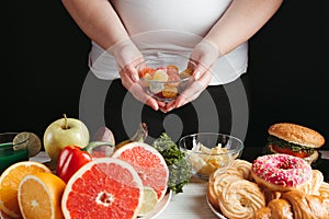 Overweight woman choosing unhealthy food