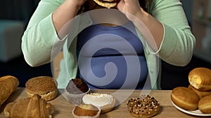 Overweight woman consuming too much bakery, eating stress with unhealthy sweets