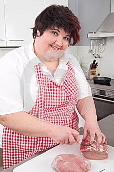 Overweight woman cutting ham
