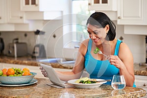Overweight Woman With Digital Tablet Checking Calorie Intake