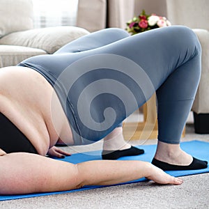 Overweight woman doing static bridge exercise