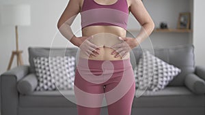 Overweight woman doing vacuum exercise at home