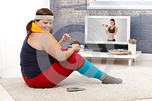 Overweight woman eating chocolate cake smiling