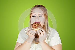 Overweight woman eating donuts in the studio