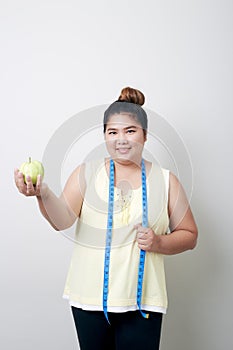 Overweight woman eating food on gray background