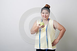 Overweight woman eating food on gray background