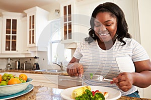 Overweight Woman Eating Healthy Meal in Kitchen