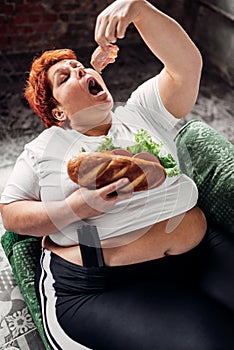 Overweight woman eats sandwich, bulimic, obesity