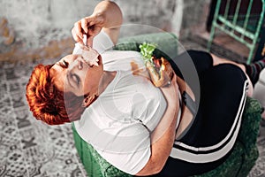 Overweight woman eats sandwich, bulimic, obesity