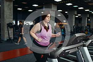 Overweight woman, exercise on treadmill in gym