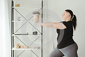 Overweight woman exercising in her living room