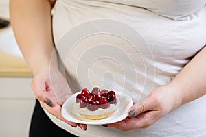 Overweight woman fed up with diets eating a cake