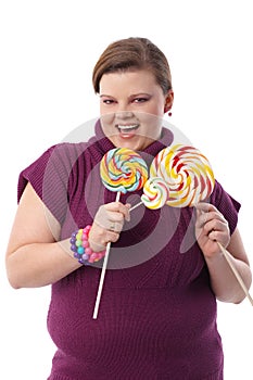 Overweight woman with huge lollipops smiling