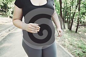 Overweight woman losing weight running in park