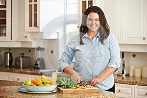 Nadváha žena príprava zelenina v kuchyňa 