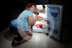 Overweight woman with refrigerator