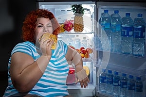 Overweight woman with refrigerator