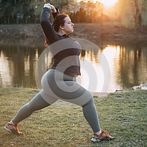 Overweight woman relaxing doing yoga at park