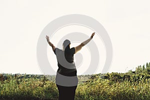 Overweight woman rising hands to the sky